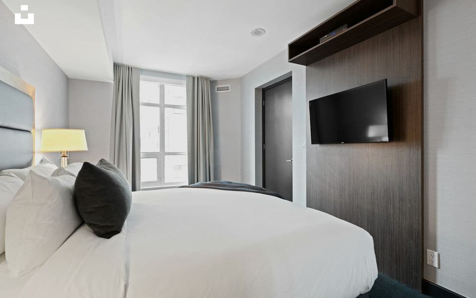Upscale hospitality suite featuring a wall-mounted television and warm interior decor