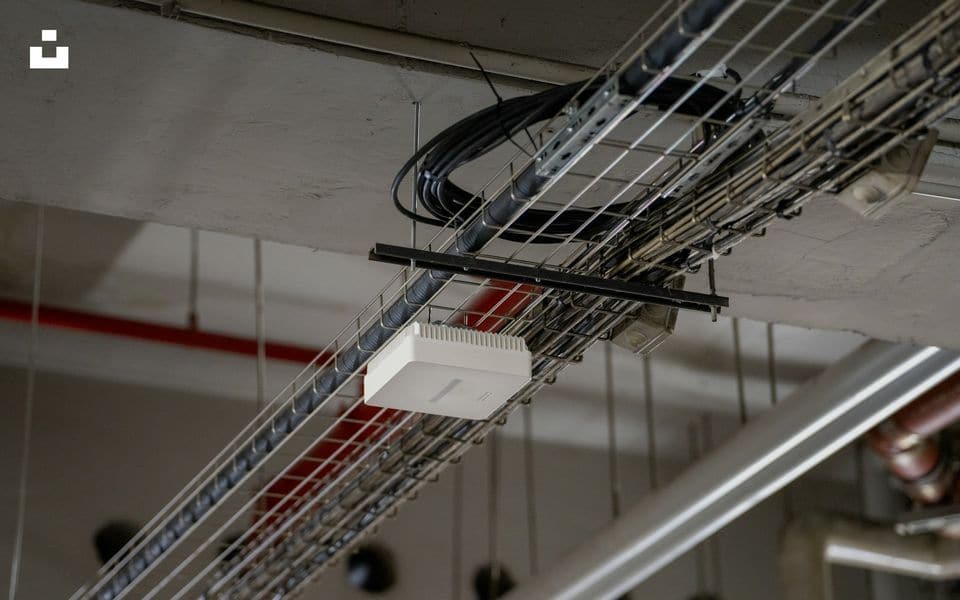 Enterprise Wi-Fi access point mounted beneath utility ceiling with structured cabling